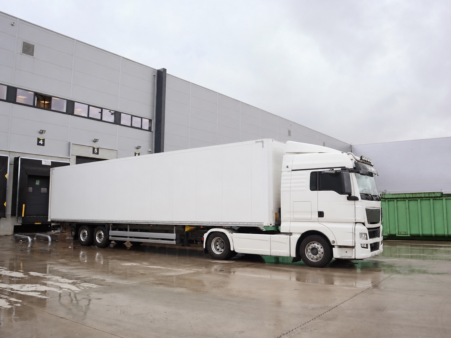 Unbranded logistics truck positioned at a warehouse loading dock.
